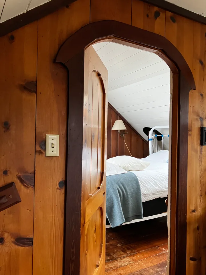 An arched pine doorway into the attic bedroom