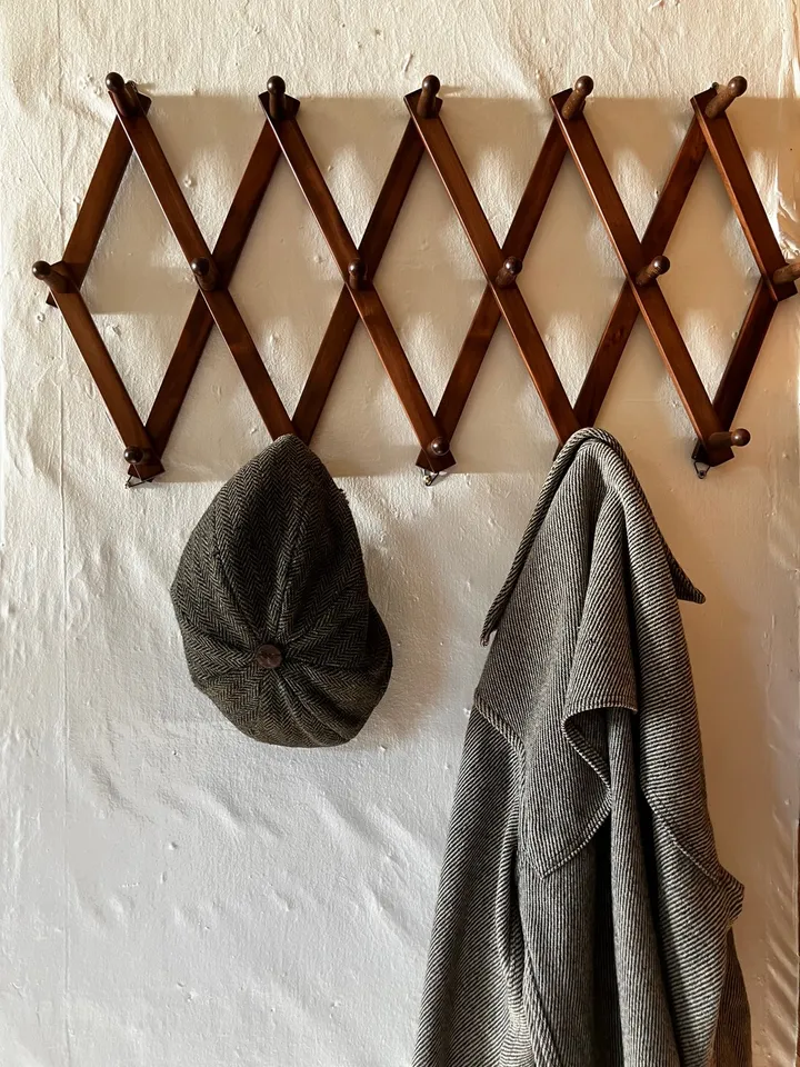 A herringbone cap and wool coat on the entry peg rack