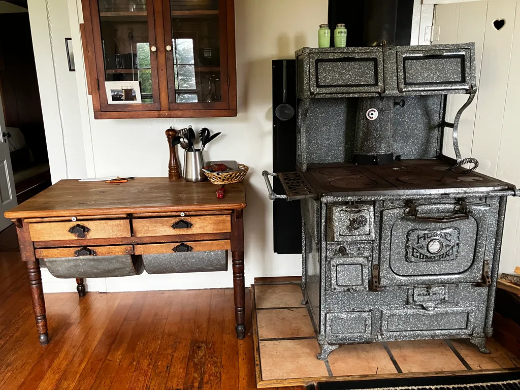 The kitchen with an antique speckled enamel range and pine work table